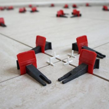 Tile levelling system with plastic clips and wedges. Close-up view